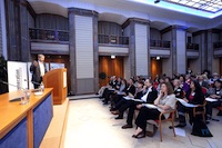 Ein Saal mit Publikum und einem Redner