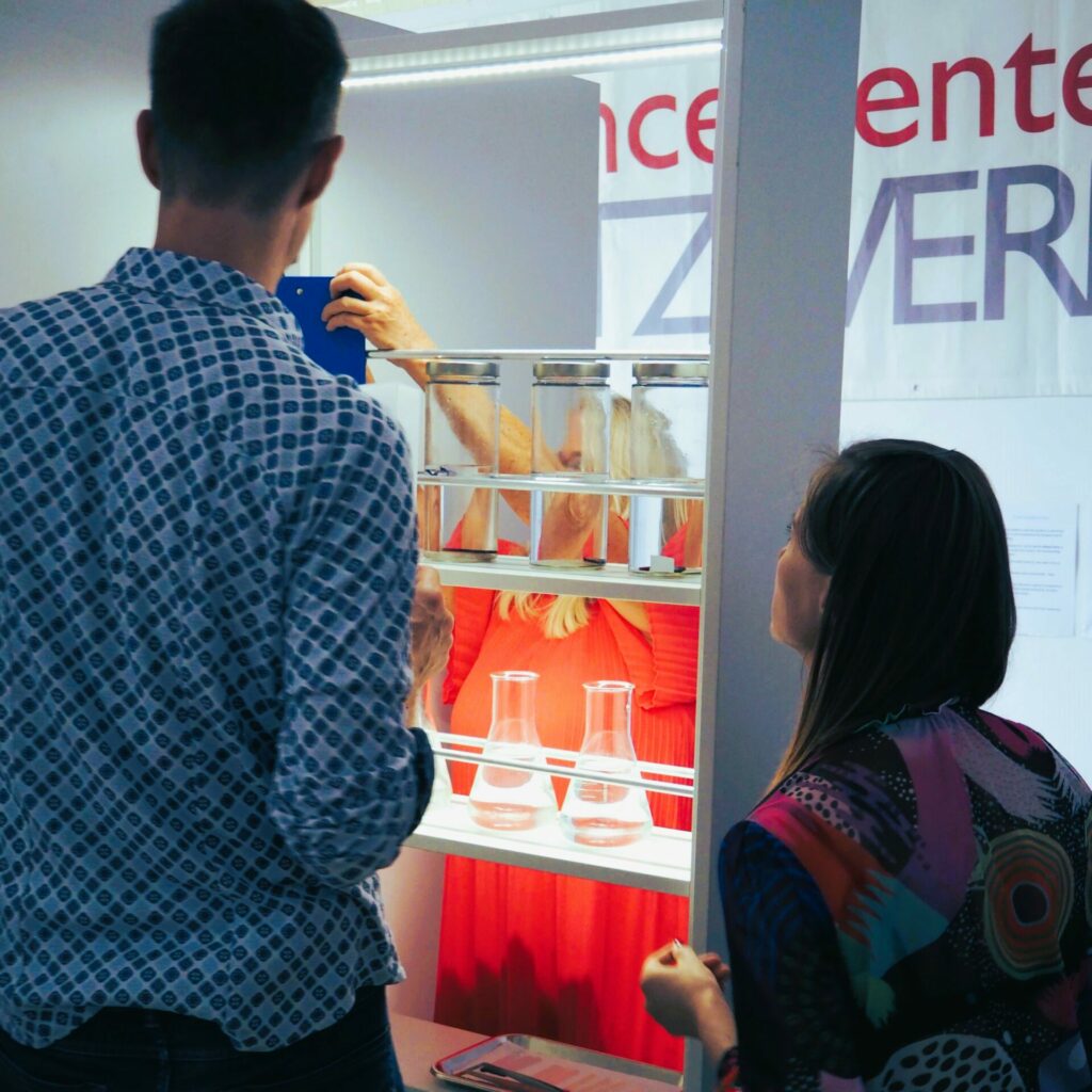 3 Personen experimentieren mit Laborgläsern und Flüssigkeiten