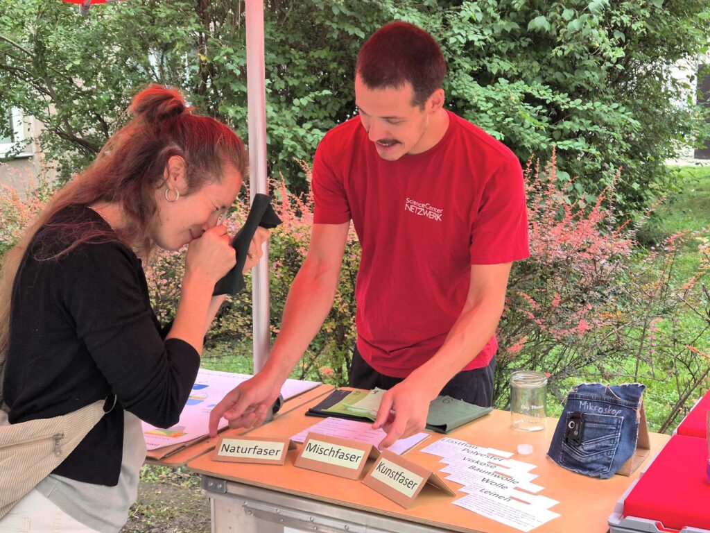 2 Personen an einem Marktstand mit Mikroskop